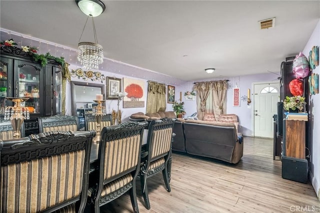 dining space featuring a notable chandelier and light hardwood / wood-style flooring