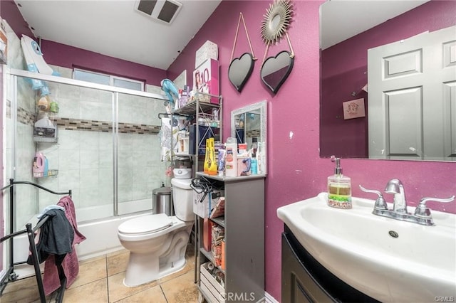 full bathroom with vanity, toilet, tile patterned flooring, and bath / shower combo with glass door