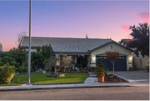 ranch-style home with a yard and a garage