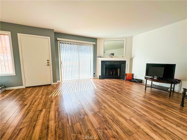 unfurnished living room featuring hardwood / wood-style floors and a tiled fireplace