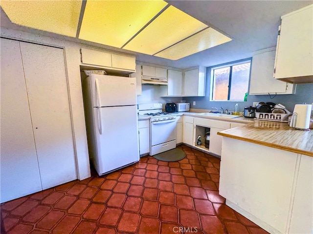 kitchen featuring sink, white cabinetry, and white appliances