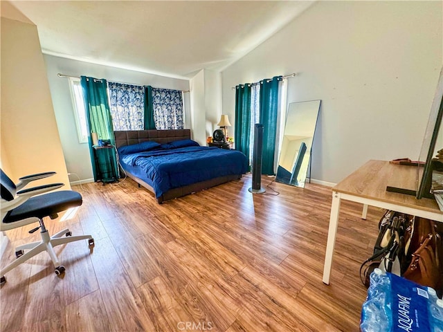 bedroom with hardwood / wood-style floors and vaulted ceiling