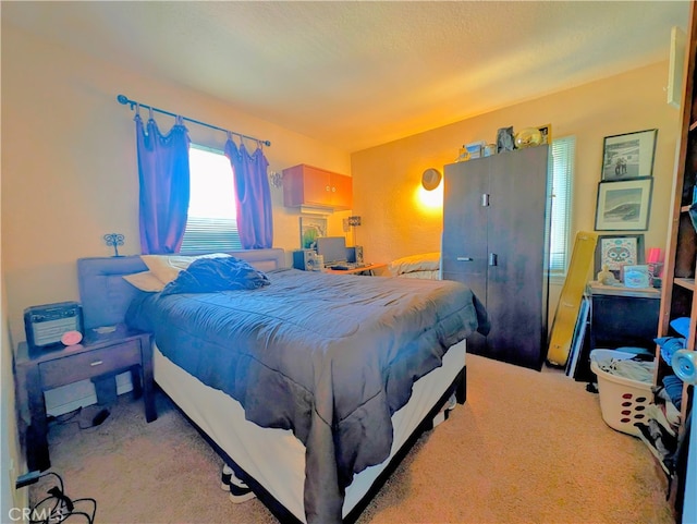 bedroom with a textured ceiling and light colored carpet