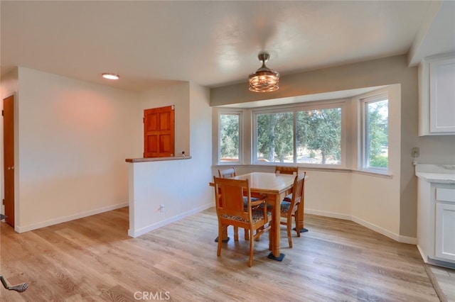 dining room featuring light wood finished floors and baseboards