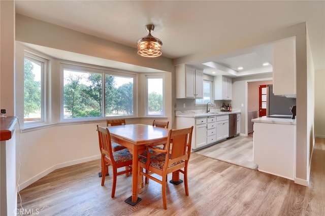 dining room with a wealth of natural light, light wood-type flooring, and sink