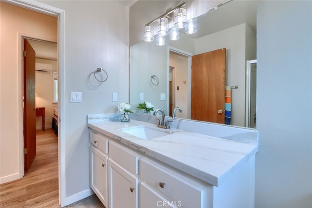 bathroom with vanity, baseboards, and wood finished floors
