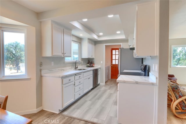 kitchen with white cabinets, a sink, stainless steel appliances, and recessed lighting