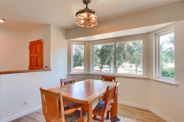 dining area featuring baseboards and light wood finished floors