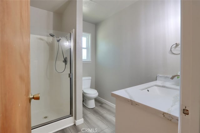 bathroom featuring vanity, toilet, and a shower with door