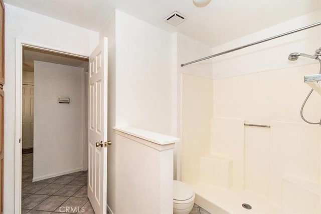 bathroom featuring tile patterned floors, toilet, and walk in shower