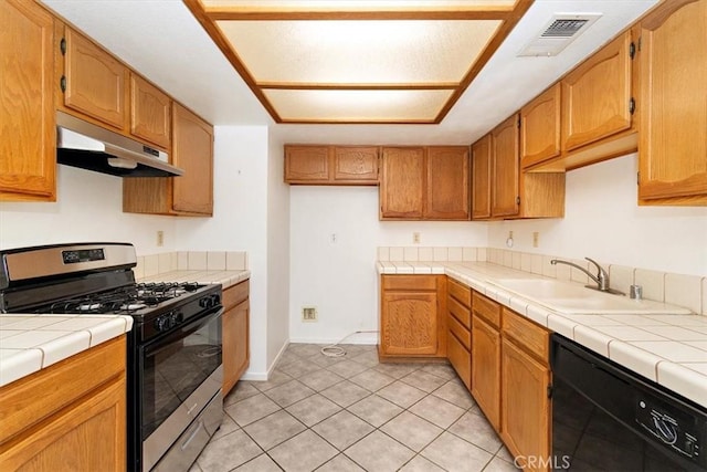 kitchen with tile countertops, dishwasher, sink, stainless steel gas range, and light tile patterned floors