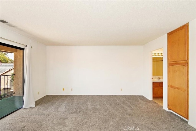 carpeted spare room with a textured ceiling