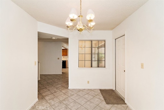 unfurnished dining area featuring light tile patterned flooring, a textured ceiling, and an inviting chandelier