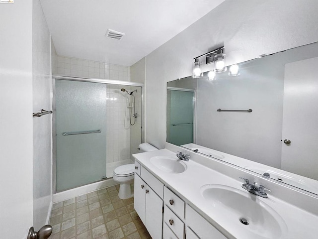 bathroom featuring vanity, toilet, and a shower with shower door