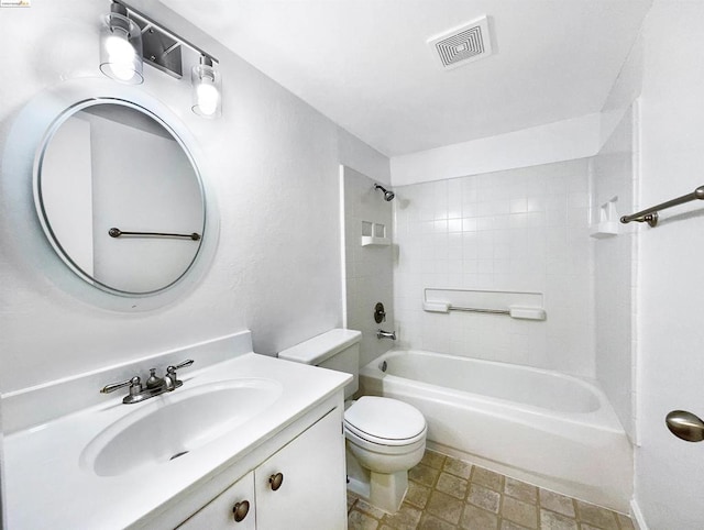 full bathroom with tiled shower / bath, vanity, and toilet