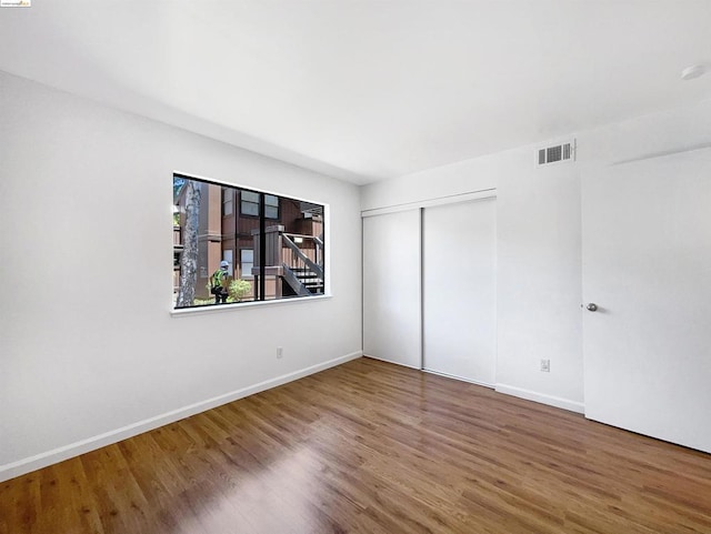 unfurnished bedroom featuring hardwood / wood-style floors and a closet