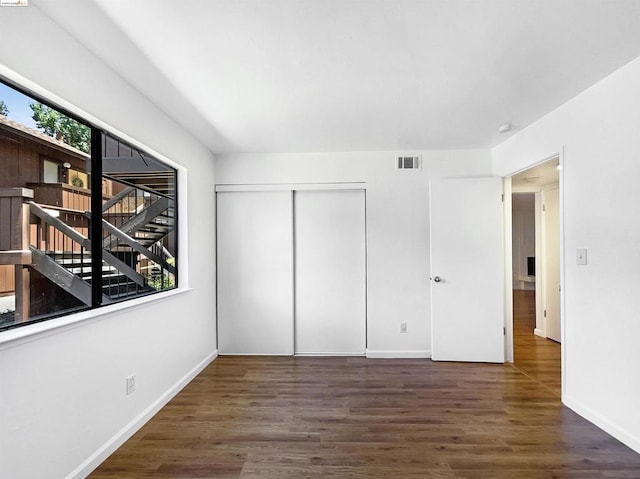 unfurnished bedroom featuring dark hardwood / wood-style floors and a closet