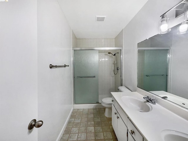 bathroom featuring vanity, toilet, and a shower with door