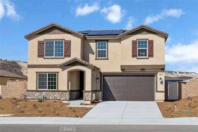 view of front of property featuring driveway, stone siding, solar panels, and stucco siding