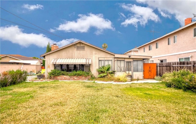 rear view of property featuring a lawn