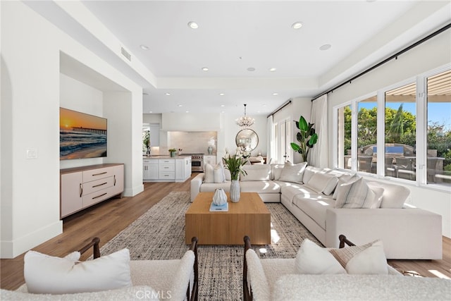 living room with a chandelier and light wood-type flooring