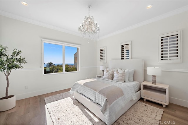 bedroom with hardwood / wood-style flooring, crown molding, and a chandelier