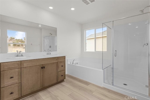 bathroom with hardwood / wood-style flooring, plus walk in shower, and vanity