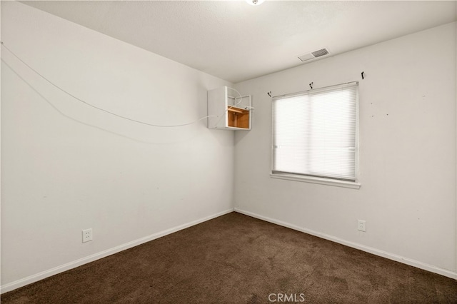 unfurnished room featuring dark carpet