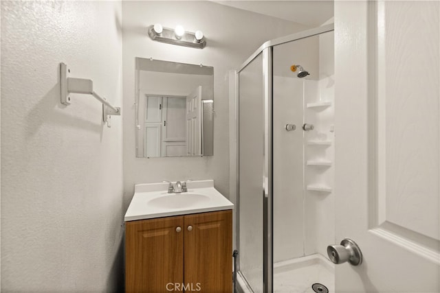 bathroom featuring vanity and a shower with shower door