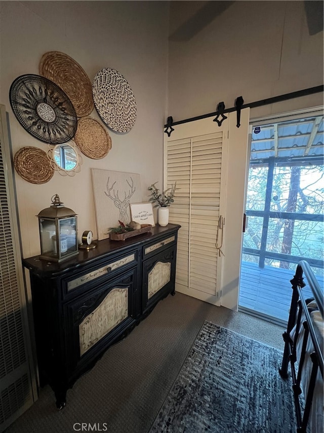 interior space with dark colored carpet and a barn door