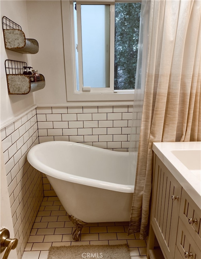 bathroom with a tub to relax in, tile walls, and tile patterned floors