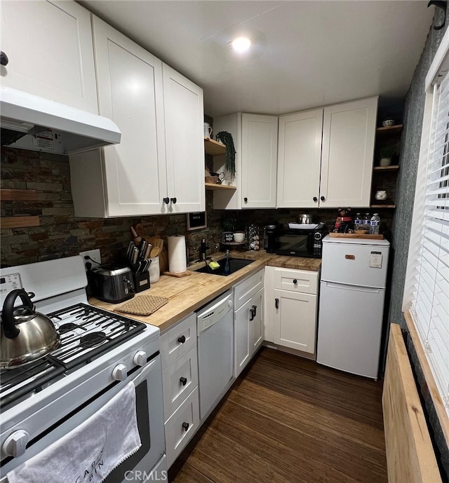 kitchen featuring backsplash, white appliances, white cabinetry, and butcher block counters