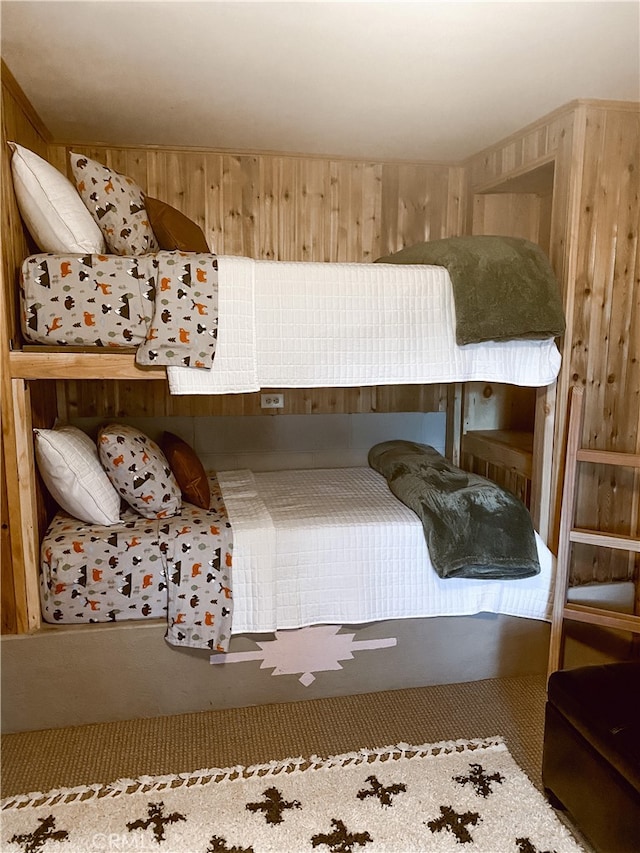 bedroom with carpet floors and wood walls