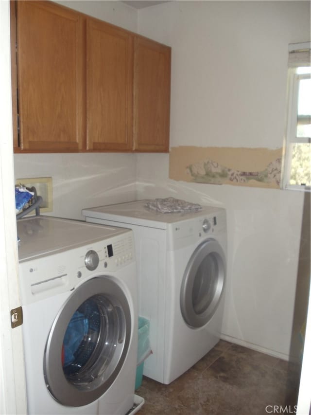 laundry area with washing machine and dryer and cabinets