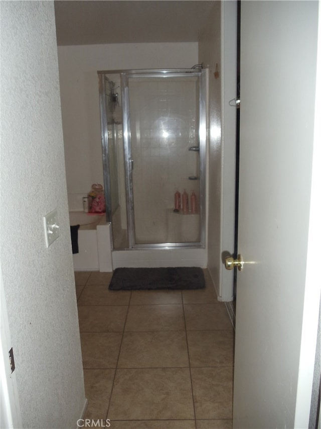 bathroom featuring an enclosed shower and tile patterned flooring