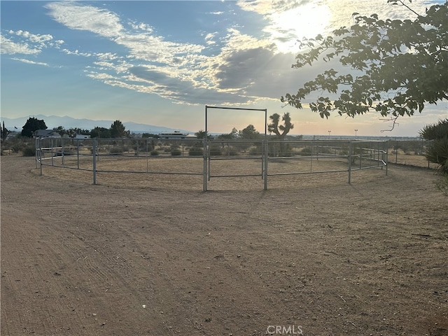 yard at dusk with a mountain view and a rural view