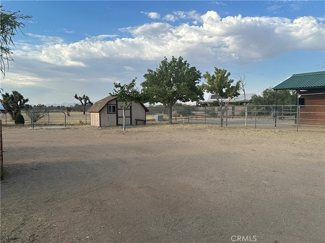 view of yard with a rural view and a storage shed