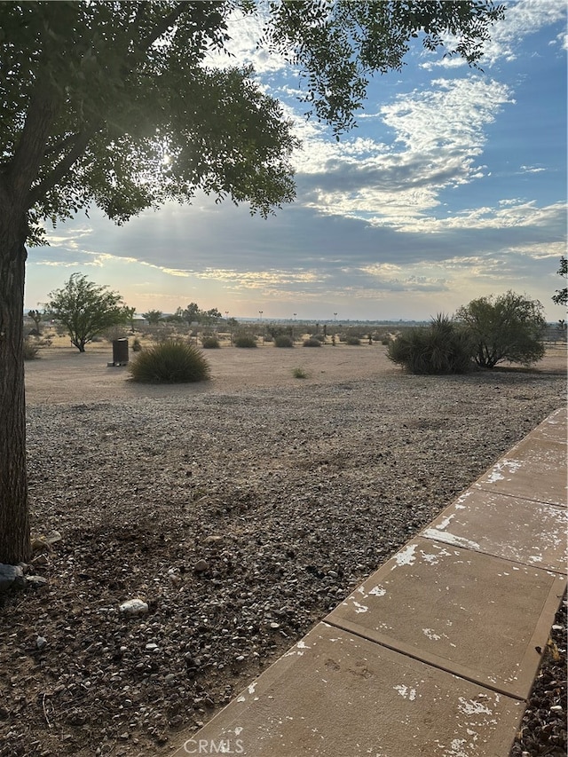 yard at dusk featuring a rural view