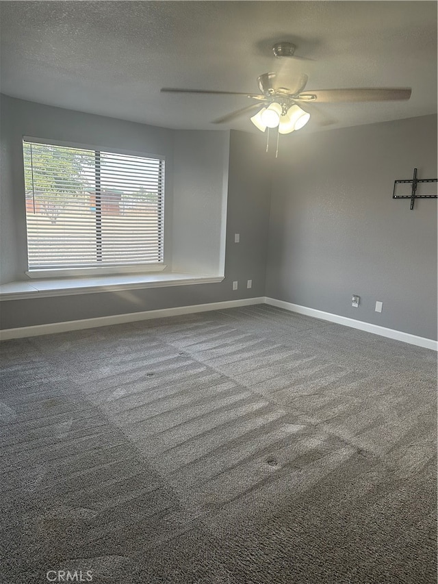 spare room featuring ceiling fan, a textured ceiling, and carpet flooring