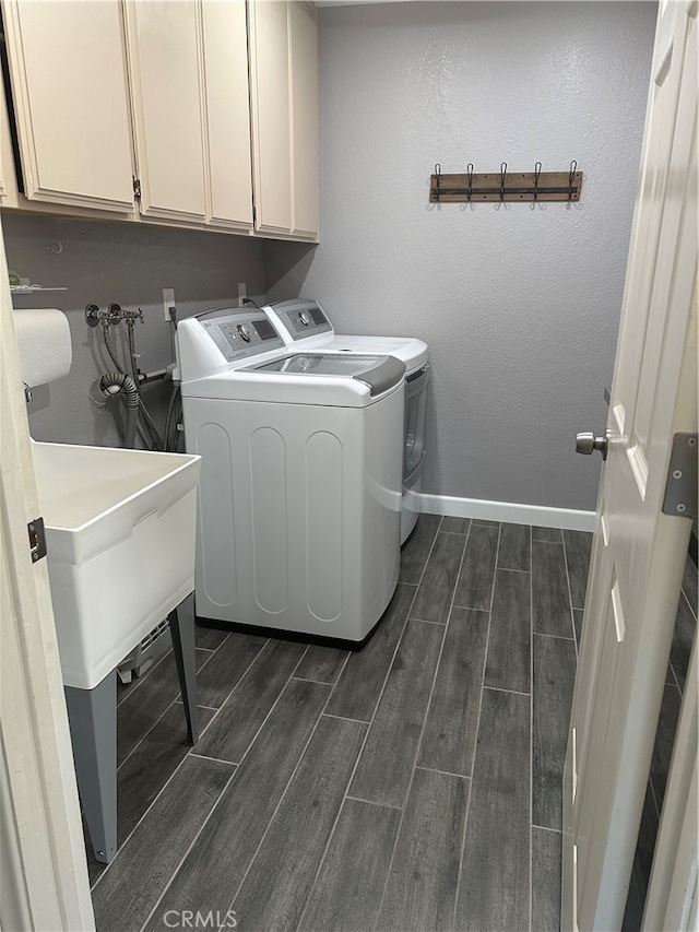 washroom with cabinets, dark hardwood / wood-style floors, and washing machine and dryer