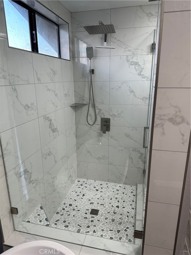 bathroom with a shower with door