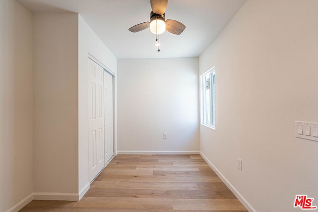 unfurnished bedroom featuring ceiling fan, light wood-type flooring, and a closet