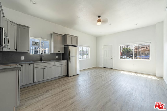 kitchen featuring gray cabinets, appliances with stainless steel finishes, and a healthy amount of sunlight