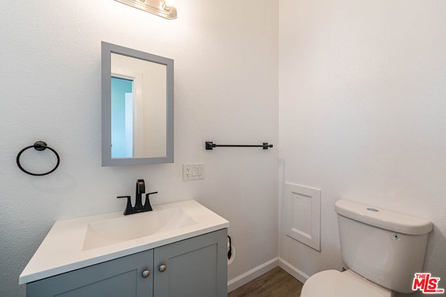 bathroom featuring wood-type flooring, vanity, and toilet