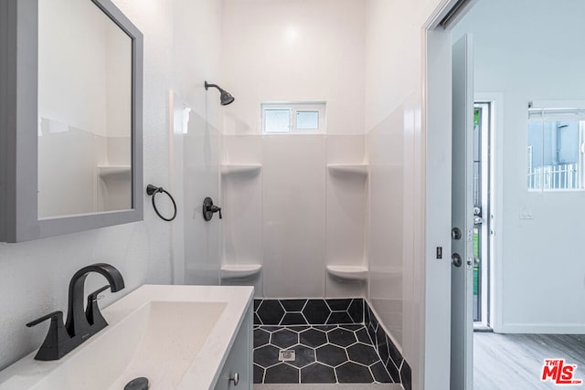 bathroom featuring walk in shower, tile patterned floors, and vanity