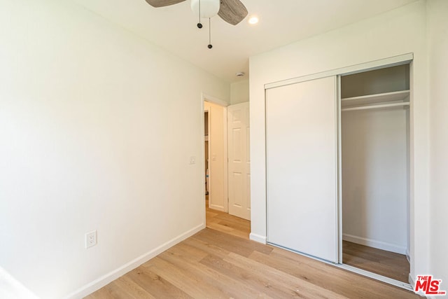 unfurnished bedroom featuring ceiling fan, a closet, and light hardwood / wood-style flooring