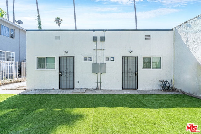 rear view of property with a yard