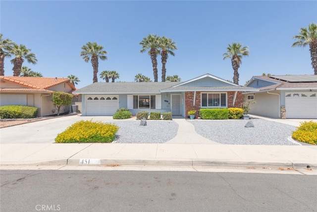 ranch-style home featuring solar panels and a garage