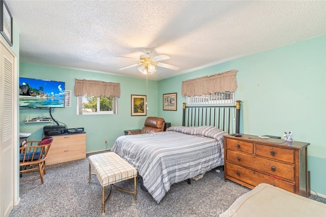 carpeted bedroom featuring ceiling fan and a textured ceiling