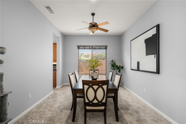 dining area with light colored carpet and ceiling fan